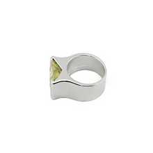 Silver ring with a yellow gemstone on a white background