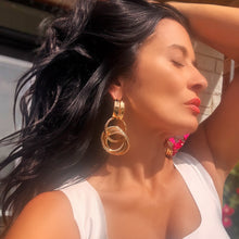 Woman wearing gold hoop earrings with a blurred background