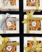 Five boxes of  taralli cookies  with decorative bows on a black textured background