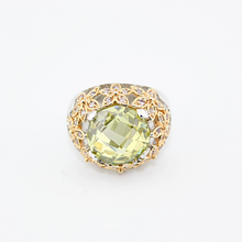 Gold ring with a green gemstone on a white background