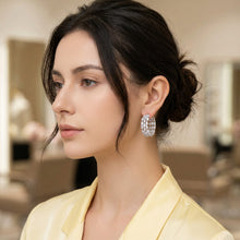 Close-up of a person wearing a sparkling silver earring.