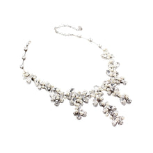 Silver necklace with floral design on a white background