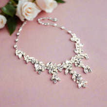 Silver necklace with floral design on a white background