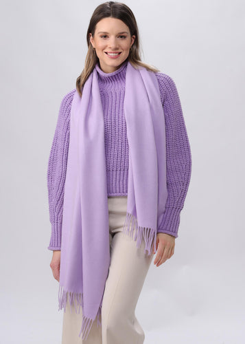 Woman wearing a purple scarf and sweater on a white background