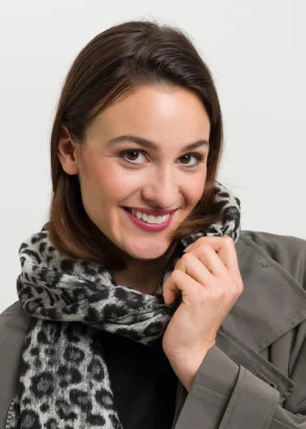 Woman wearing a patterned scarf against a plain background