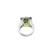Silver ring with a green gemstone on a white background