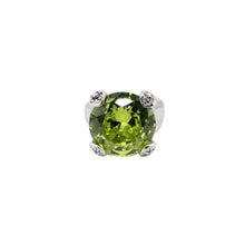Green gemstone in a silver setting on a white background