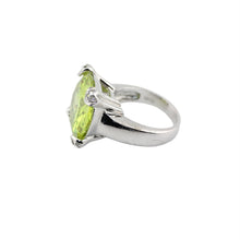Silver ring with a green gemstone on a white background