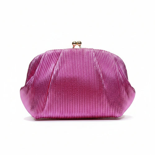 A hand holding a metallic magenta pink pleated clutch purse with a small gold clasp, set against a background of vertical gold panels with warm lighting.