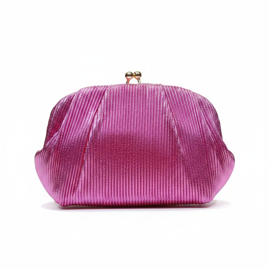 A hand holding a metallic magenta pink pleated clutch purse with a small gold clasp, set against a background of vertical gold panels with warm lighting.
