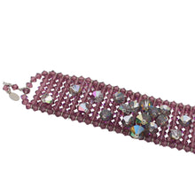 Purple beaded bracelet with embedded crystals on a light gray background