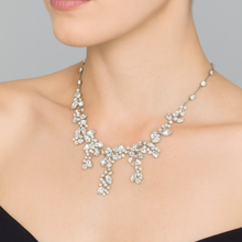 Elegant silver necklace worn by a model against a neutral background