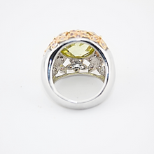 Silver ring with a yellow gemstone on a white background