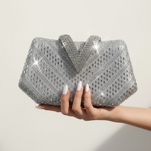 A silver rhinestone-embellished clutch bag with a prominent V-shaped top detail, displayed on a white surface against a white background.